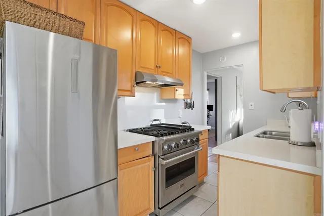 a kitchen with stainless steel appliances a refrigerator stove and sink