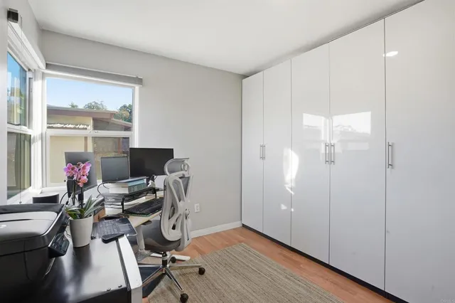 a view of a workspace with furniture and a window