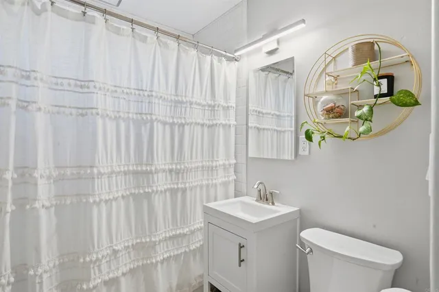 a bathroom with a sink a toilet and a mirror