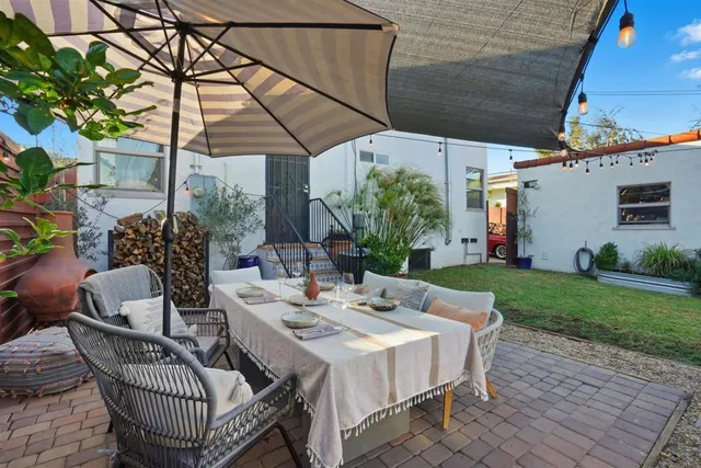a patio with a table and chairs and potted plants