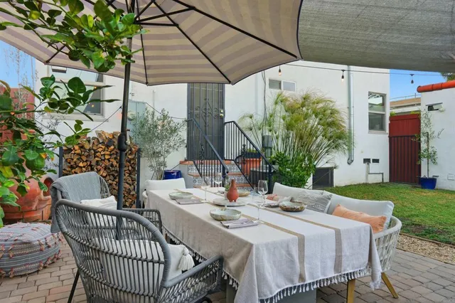 a view of a patio with a table and chairs under an umbrella