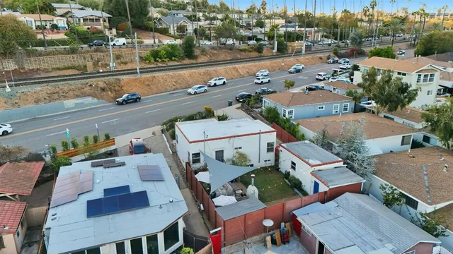a view of a patio with couches table and chairs under an umbrella