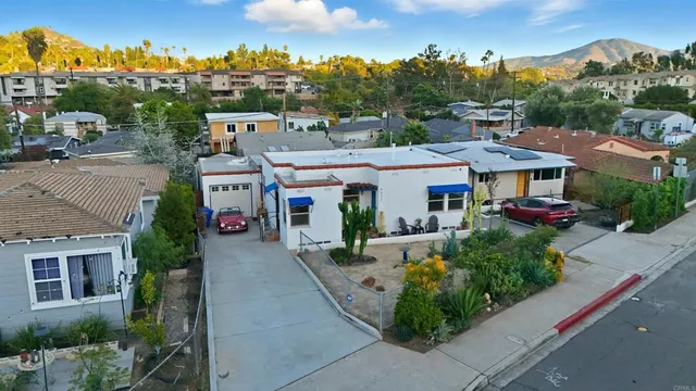 an aerial view of residential houses with outdoor space and parking