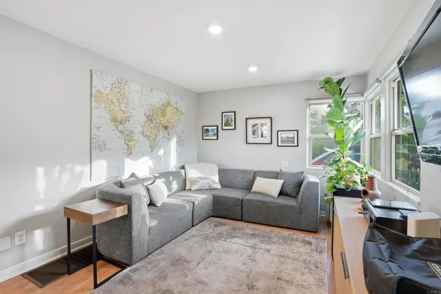 a living room with furniture potted plant and a large window