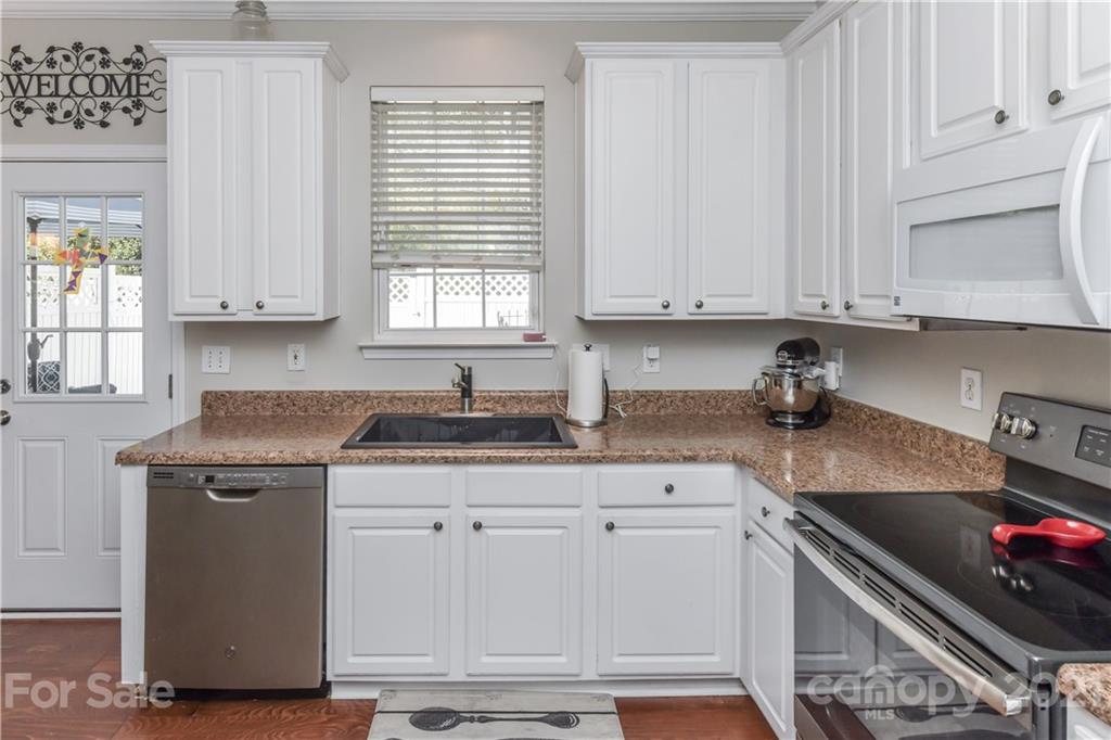 732 Shellstone Place, Unit 732 Fort Mill, SC 29708 - Photo 17 of 28 a kitchen with granite countertop white cabinets and a stove