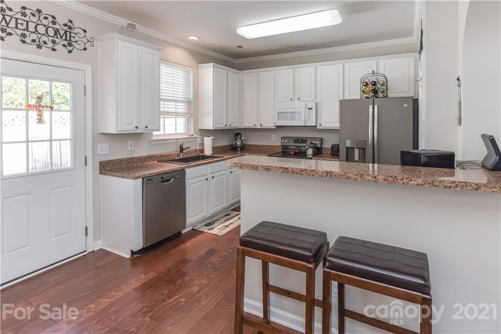 732 Shellstone Place, Unit 732 Fort Mill, SC 29708 - Photo 21 of 28 a kitchen with stainless steel appliances granite countertop a sink dishwasher a stove a refrigerator and island with wooden floor