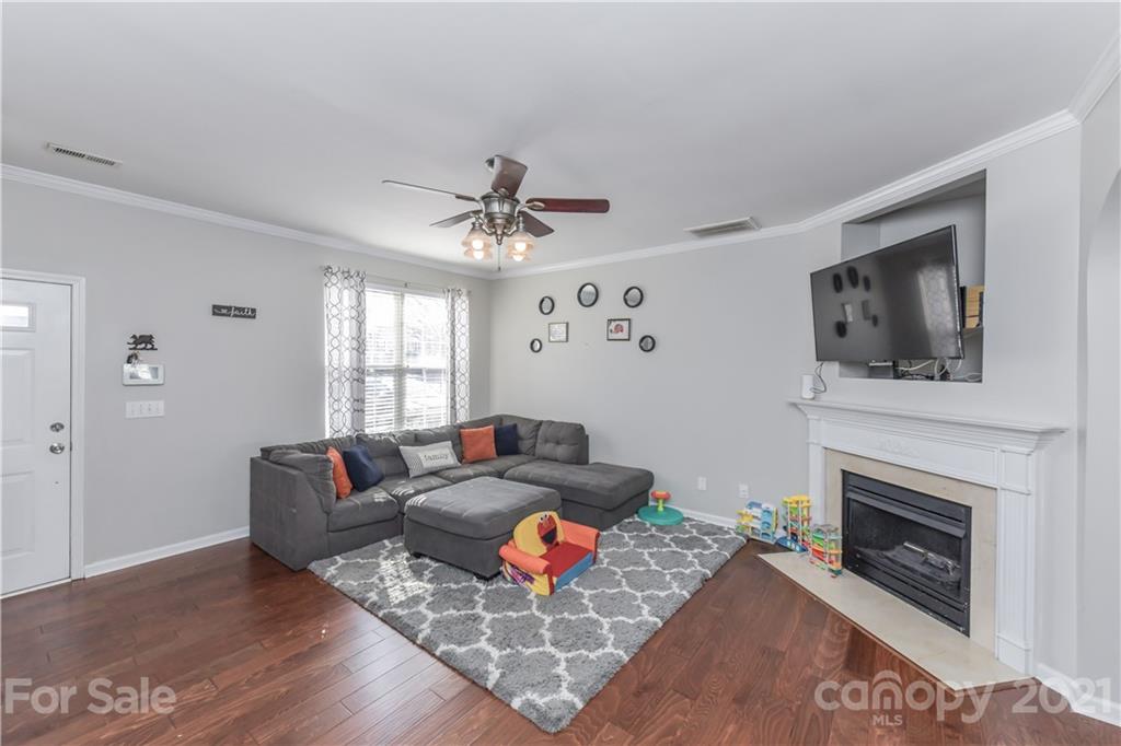 732 Shellstone Place, Unit 732 Fort Mill, SC 29708 - Photo 6 of 28 a living room with furniture a fireplace and a flat screen tv