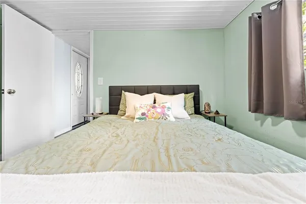 a bed room with a bed and a refrigerator