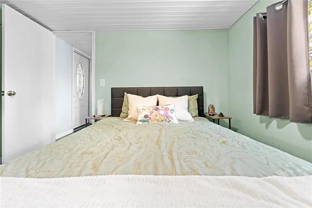 a bed room with a bed and a refrigerator