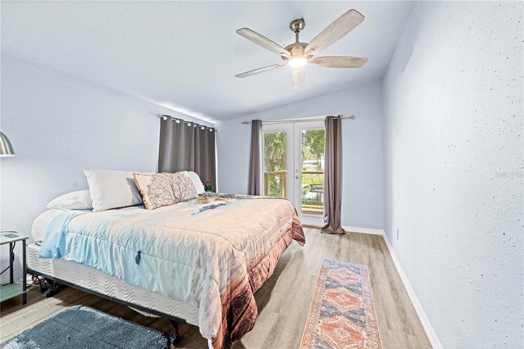 6380 Richard Drive Weeki Wachee, FL 34607 - Photo 47 of 59 a bedroom with a large bed and a chandelier