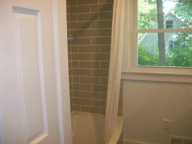 a bathroom with a shower and a window