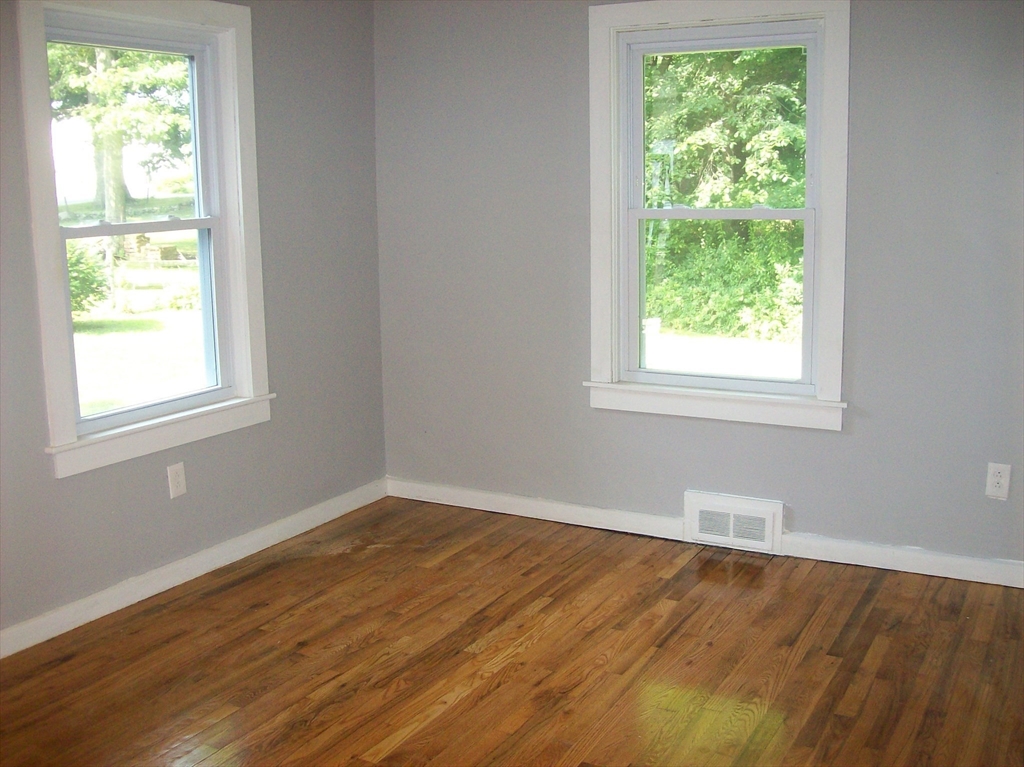 480 Pleasant Street Leicester, MA 01524 - Photo 8 of 17 an empty room with wooden floor and windows