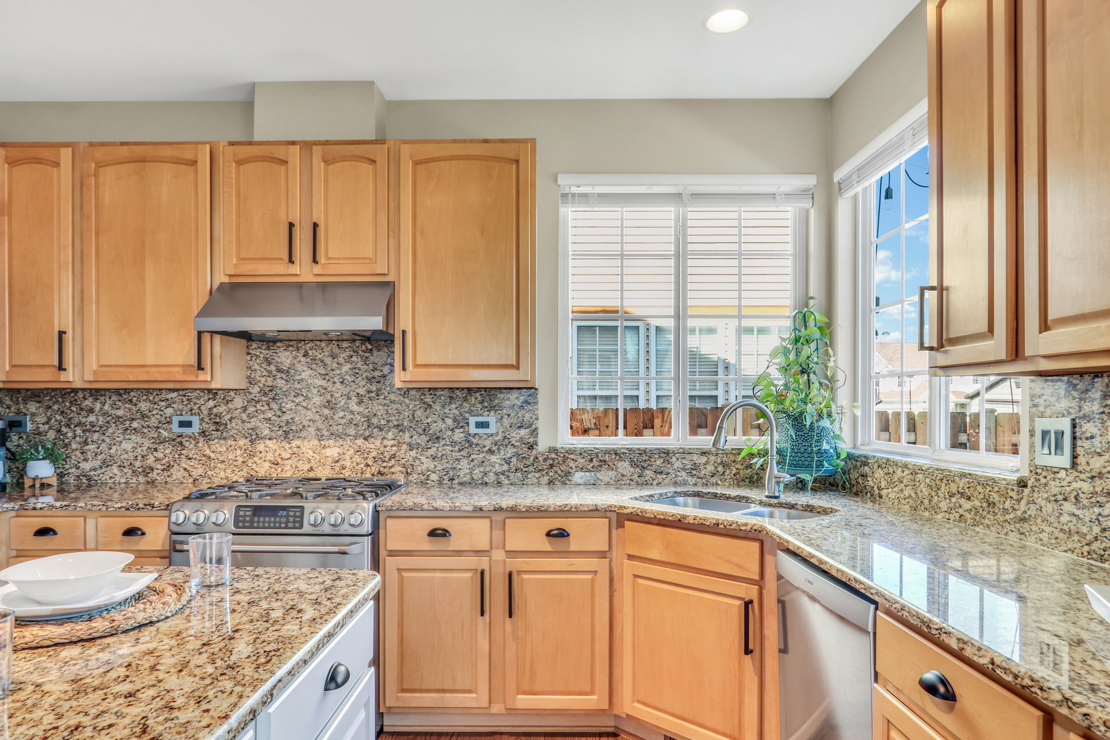 1135 Hadley Circle Gurnee, IL 60031 - Photo 15 of 60 a kitchen with granite countertop wooden cabinets a sink and a window