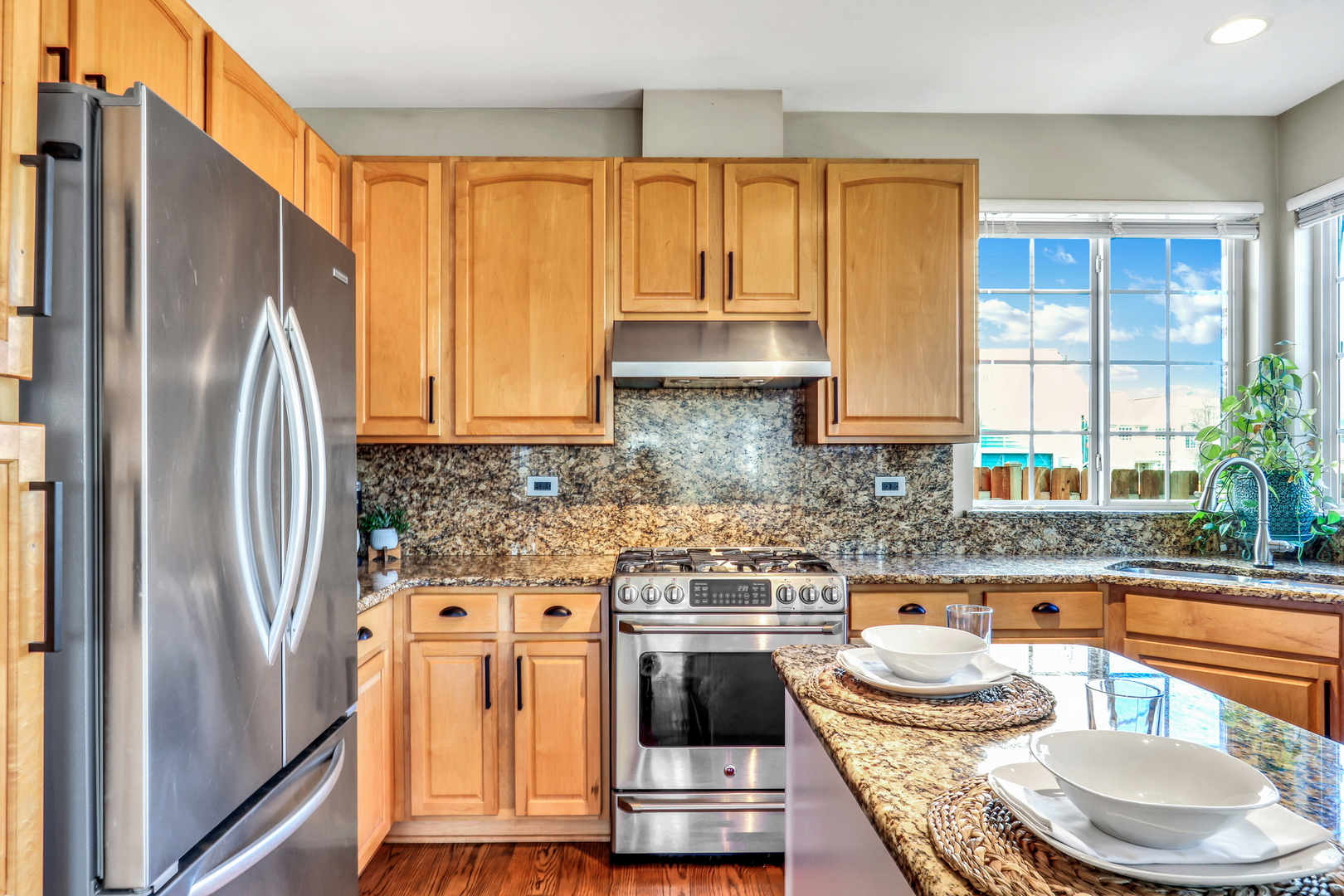 1135 Hadley Circle Gurnee, IL 60031 - Photo 18 of 60 a kitchen with stainless steel appliances granite countertop a refrigerator a stove a sink and a dining table with wooden floor
