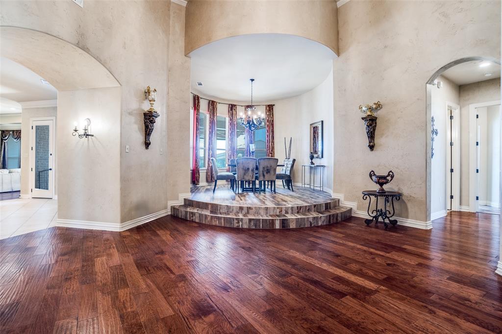 1929 Canyon Road Celina, TX 75009 - Photo 13 of 39 Foyer entrance featuring arched walkways, dark wood-style flooring, a chandelier, a high ceiling, and crown molding