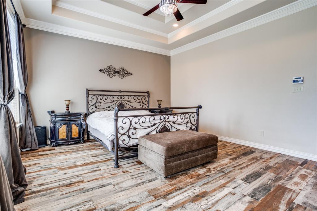 1929 Canyon Road Celina, TX 75009 - Photo 23 of 39 Bedroom with crown molding, hardwood / wood-style floors, ceiling fan, and a raised ceiling