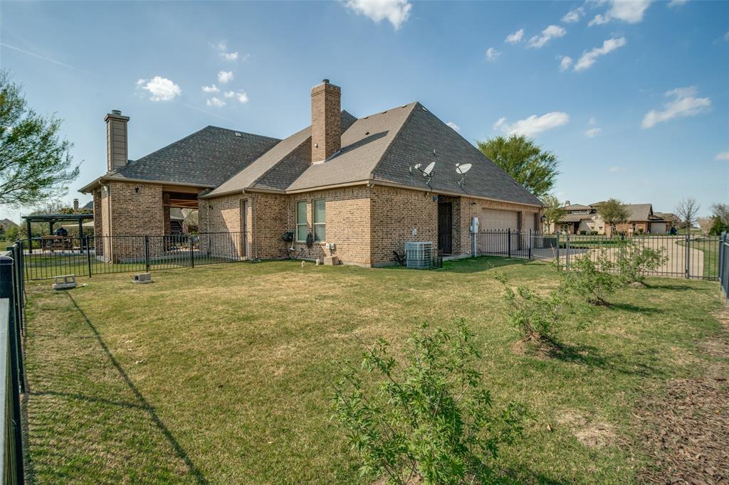 1929 Canyon Road Celina, TX 75009 - Photo 32 of 39 Rear view of property with a chimney, brick siding, roof with shingles, a fenced backyard, and an attached garage
