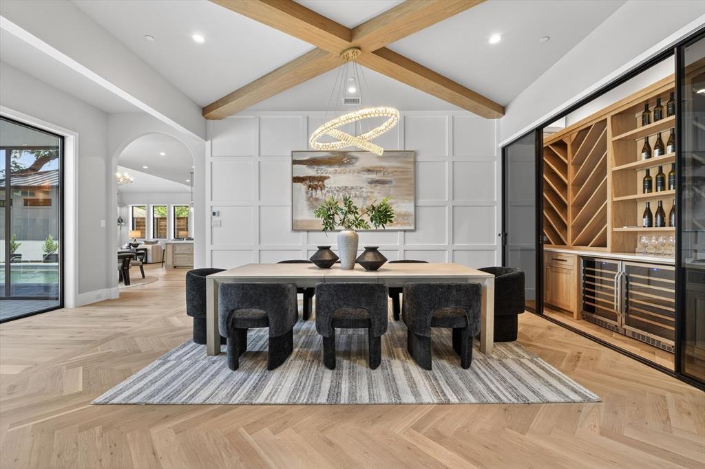 11028 Edgemere Road Dallas, TX 75230 - Photo 12 of 40 Vaulted ceiling featuring exposed wood beams, herringbone wood-finish flooring, and a built-in wine storage system with integrated coolers
