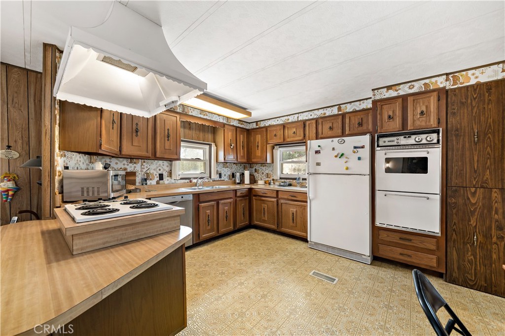 33950 Plowshare Road Wildomar, CA 92595 - Photo 25 of 62 a kitchen with refrigerator a stove a sink and cabinets