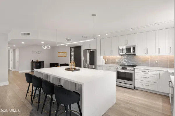 a large kitchen with kitchen island a dining table and chairs