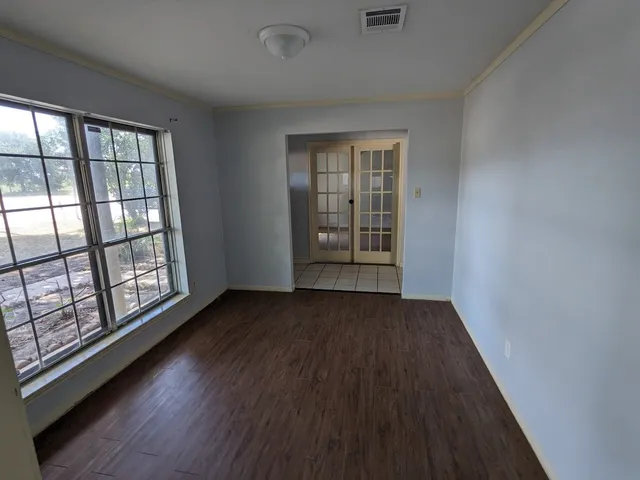 wooden floor in an empty room with a window