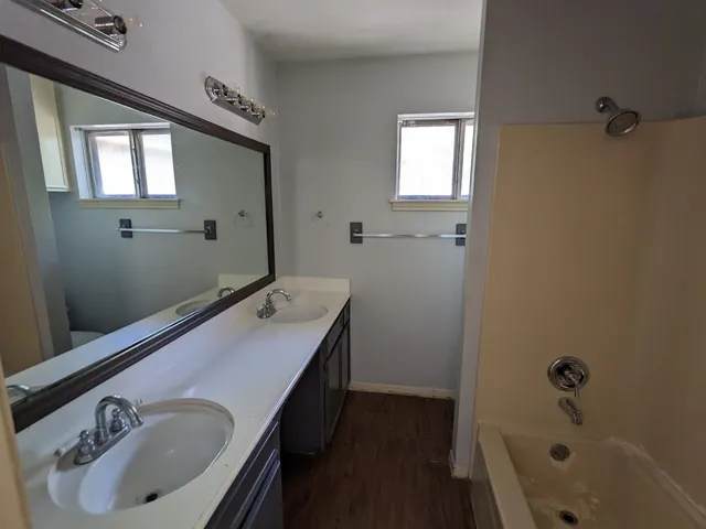 a bathroom with a tub sink and mirror