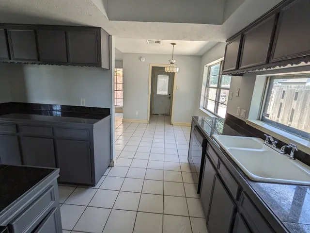 a kitchen with a sink a stove cabinets and a kitchen counter space