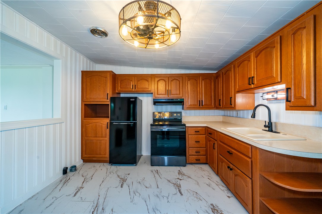 11296 Pansing Road Brookville, OH 45309 - Photo 10 of 53 This bright kitchen features wood cabinetry and modern appliances, creating a functional culinary space.
