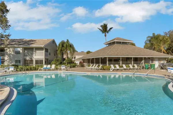 a front view of a house with swimming pool having outdoor seating