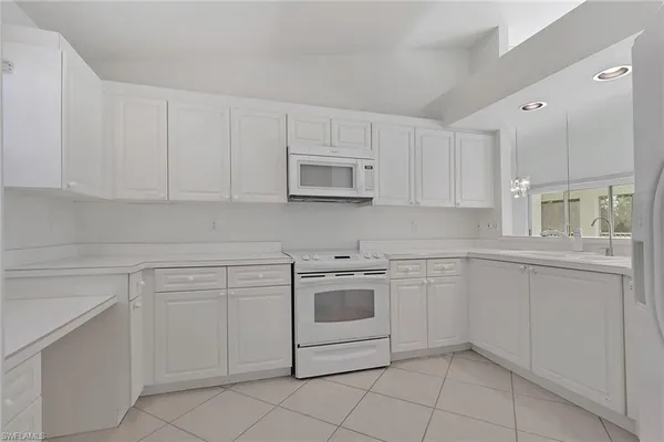a kitchen with white cabinets and white appliances