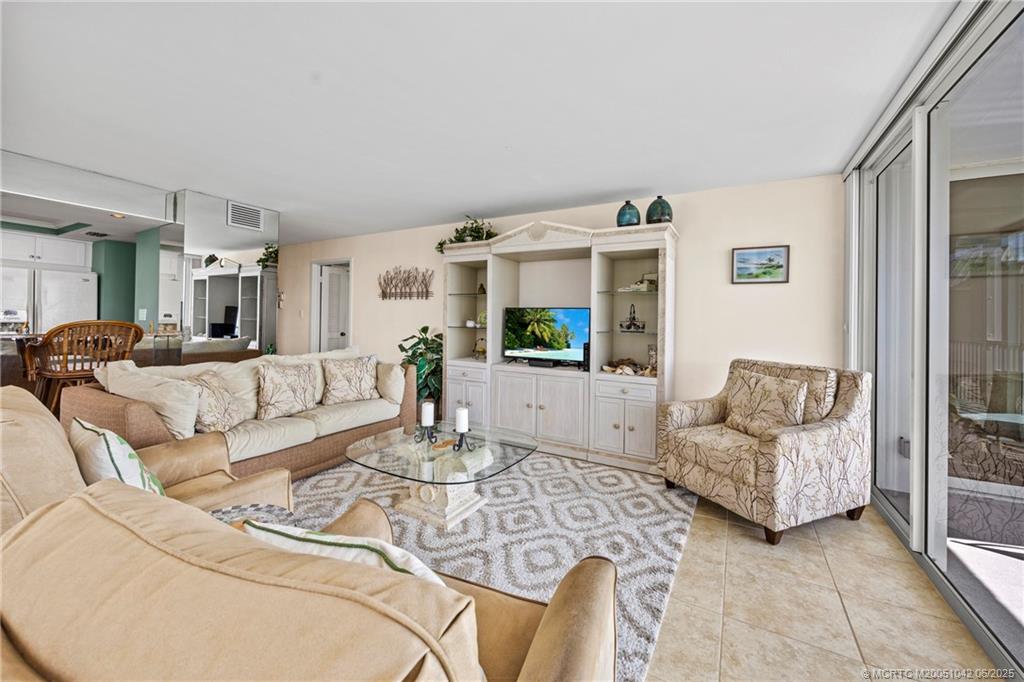 669 Northeast Plantation Road, Unit 405 Stuart, FL 34996 - Photo 17 of 34 a living room with furniture and a table