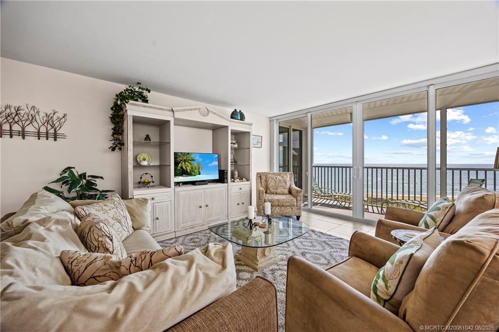 669 Northeast Plantation Road, Unit 405 Stuart, FL 34996 - Photo 18 of 34 a living room with furniture and a floor to ceiling window