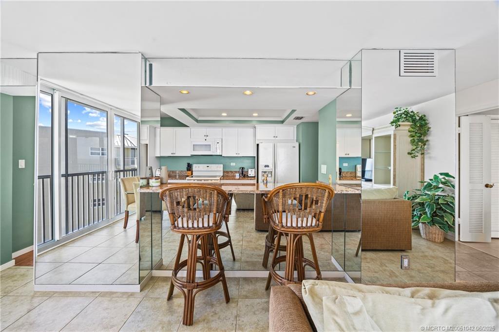 669 Northeast Plantation Road, Unit 405 Stuart, FL 34996 - Photo 20 of 34 a dining room with furniture and a floor to ceiling window