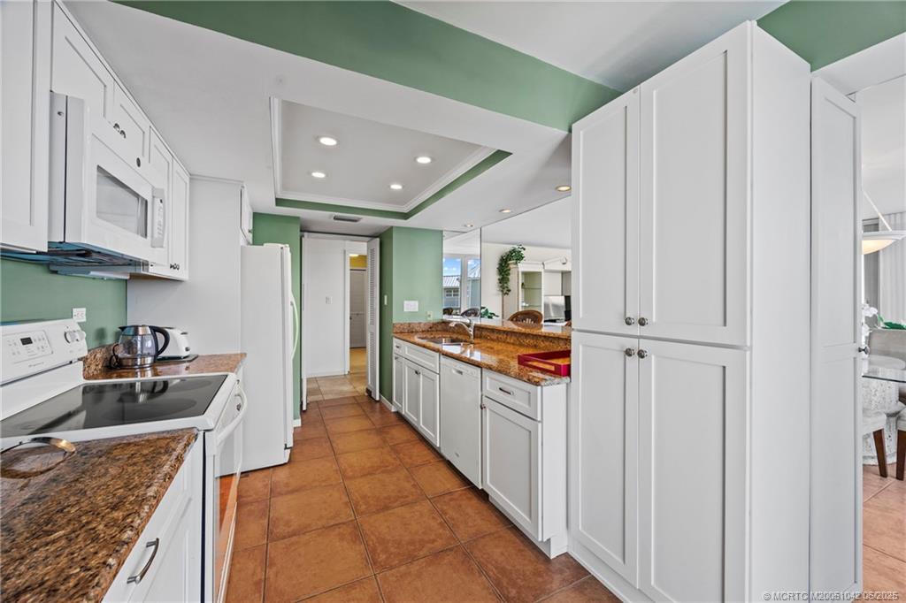 669 Northeast Plantation Road, Unit 405 Stuart, FL 34996 - Photo 23 of 34 a large white kitchen with stainless steel appliances granite countertop lots of counter top space