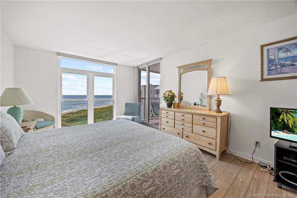 669 Northeast Plantation Road, Unit 405 Stuart, FL 34996 - Photo 25 of 34 a bedroom with a bed and a dresser next to a window