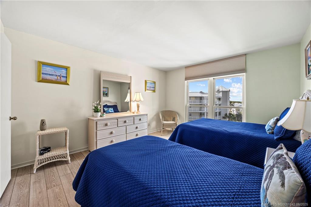 669 Northeast Plantation Road, Unit 405 Stuart, FL 34996 - Photo 29 of 34 a bedroom with a bed and a large window