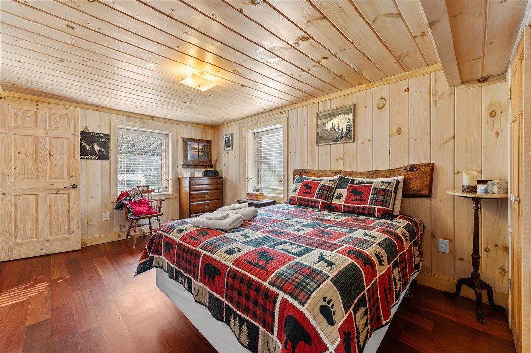 260 Hickory Ridge Mountain Rest, SC 29664 - Photo 14 of 39 This inviting bedroom features rich wooden floors and walls, creating a warm and rustic ambiance.