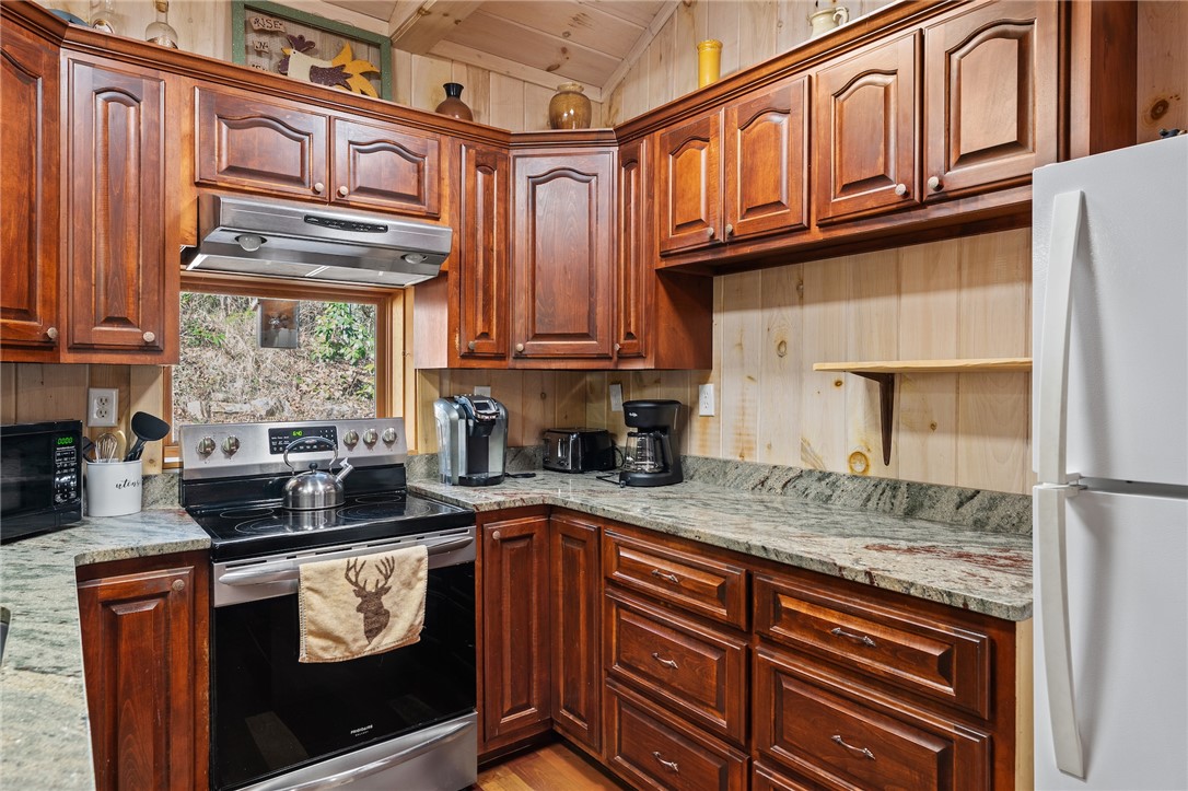 260 Hickory Ridge Mountain Rest, SC 29664 - Photo 10 of 39 This cozy kitchen features abundant wood cabinetry, granite countertops, and modern appliances, perfect for everyday living.