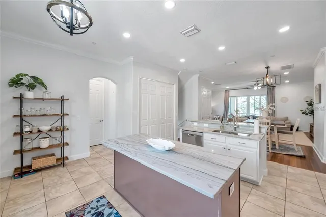 a large white kitchen with a large window and stainless steel appliances