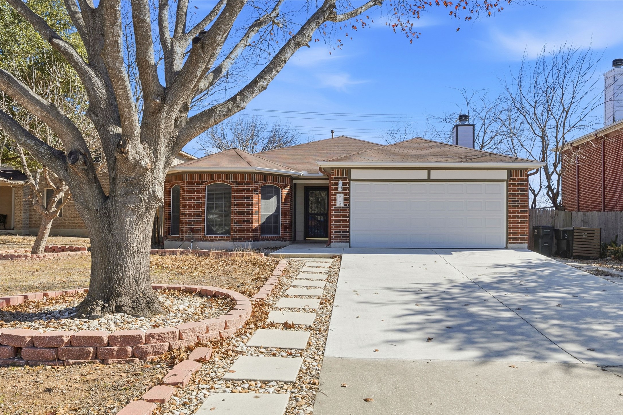 Single story home featuring, brick siding, and a two car garage.
