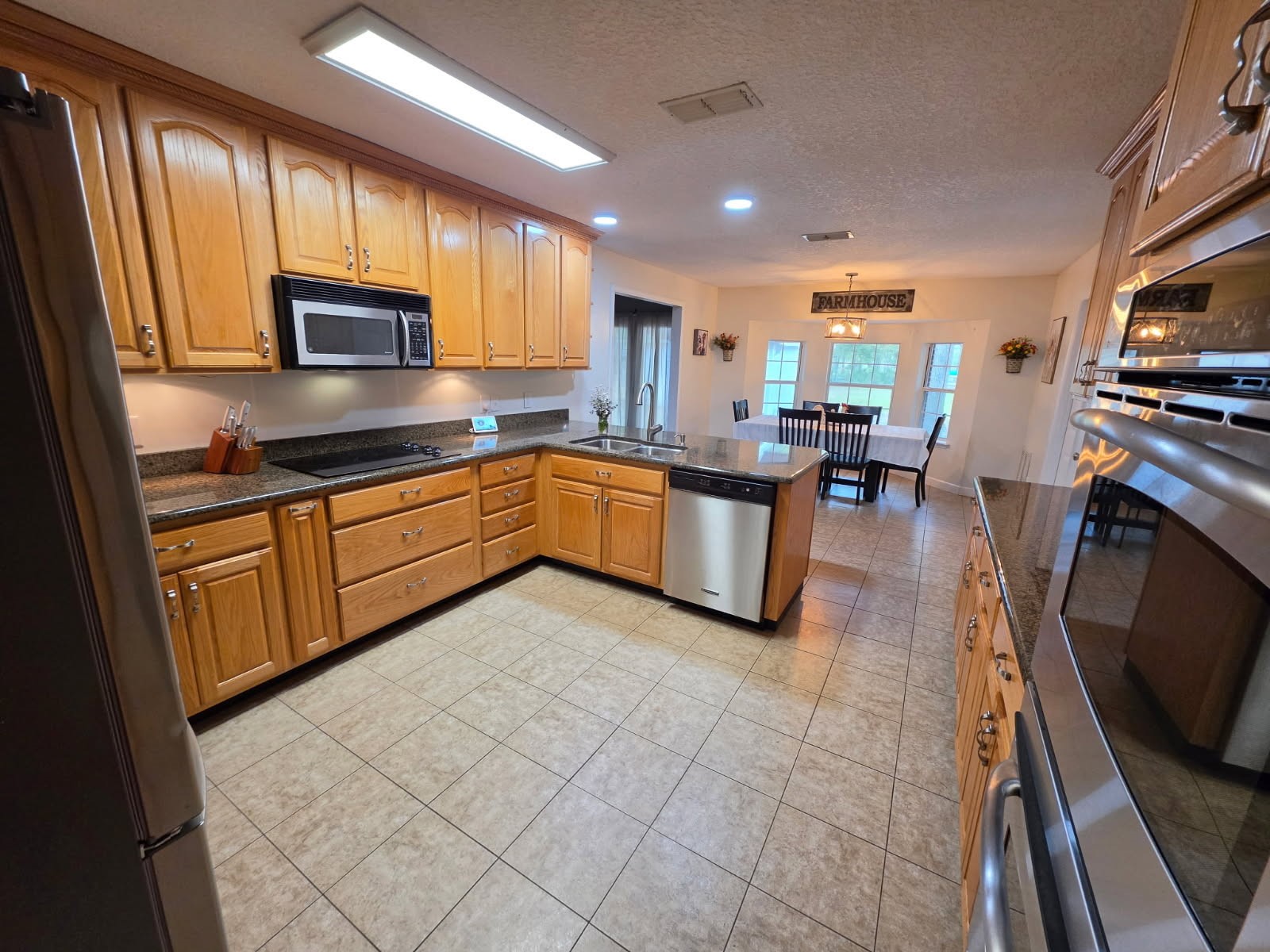17098 Cross Branch Road Hilliard, FL 32046 - Photo 61 of 71 a kitchen with stainless steel appliances granite countertop a sink counter space cabinets and a stove