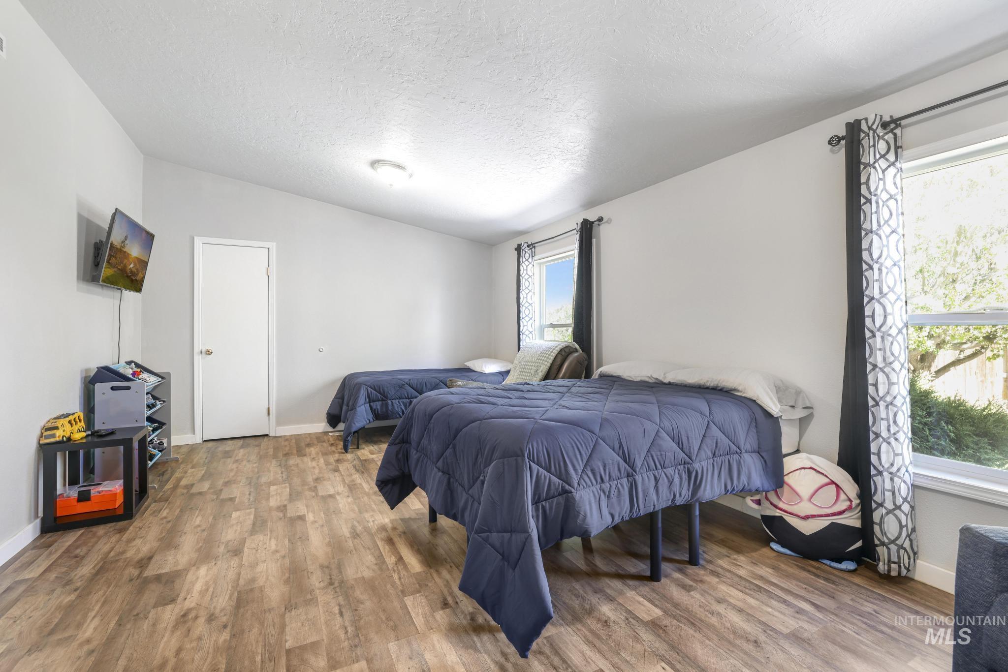309 North Grape Street Shoshone, ID 83352 - Photo 12 of 26 Bedroom with wood finished floors and a textured ceiling