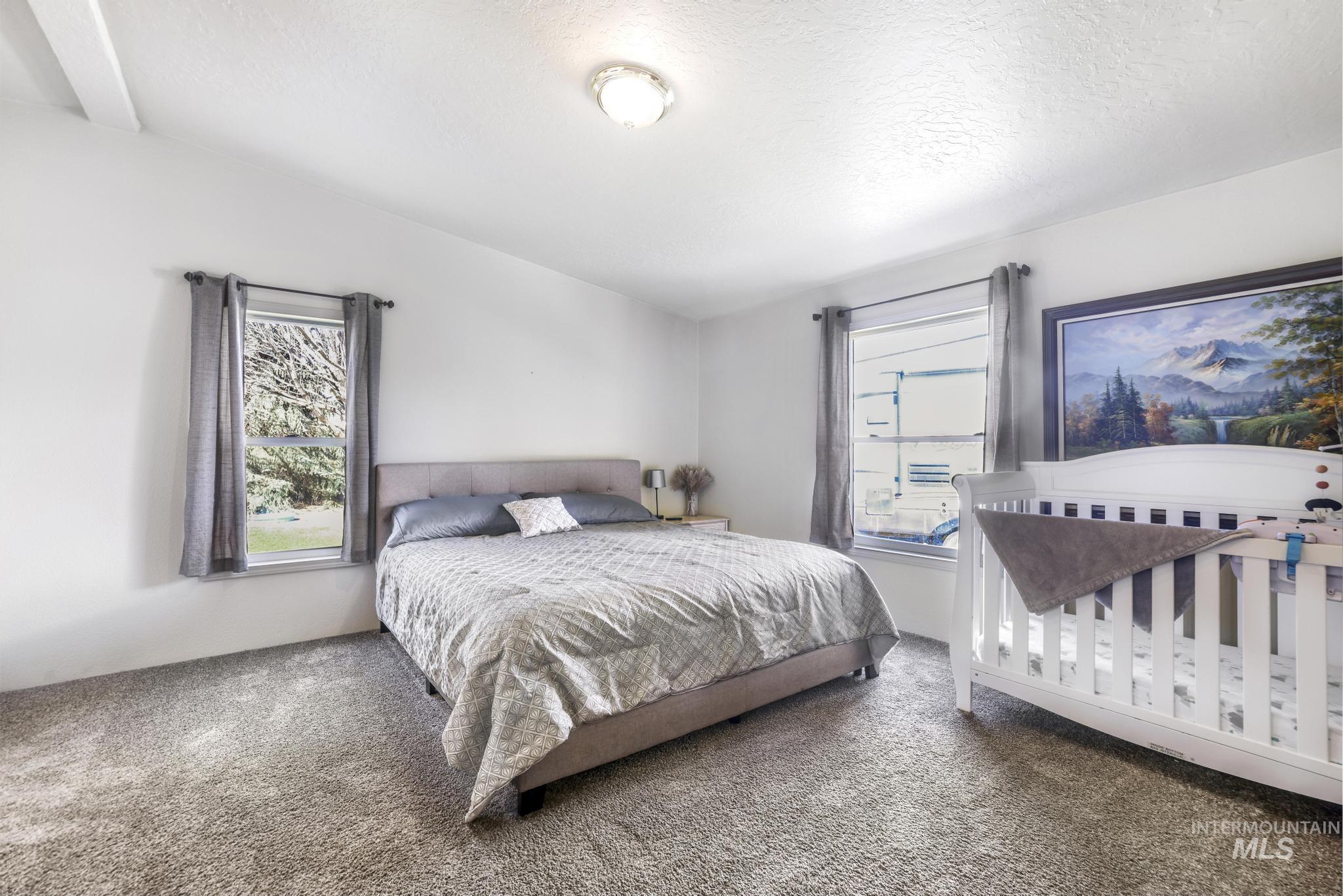 309 North Grape Street Shoshone, ID 83352 - Photo 13 of 26 Carpeted bedroom with a textured ceiling and multiple windows
