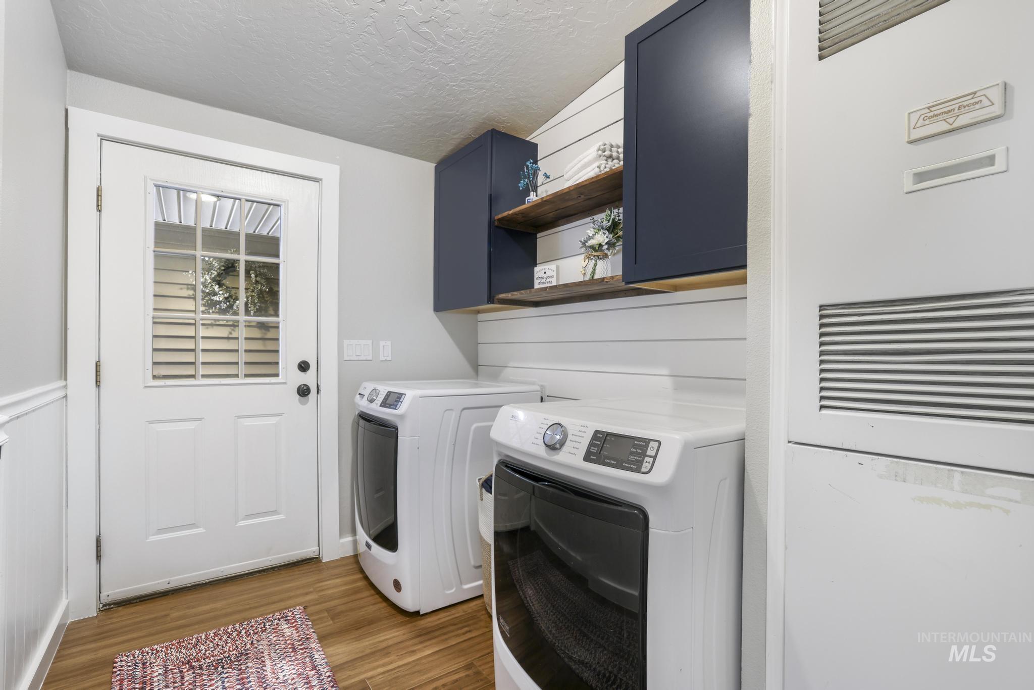 309 North Grape Street Shoshone, ID 83352 - Photo 16 of 26 Laundry room featuring a heating unit, a textured ceiling, dark wood-style floors, washer and dryer, and cabinet space