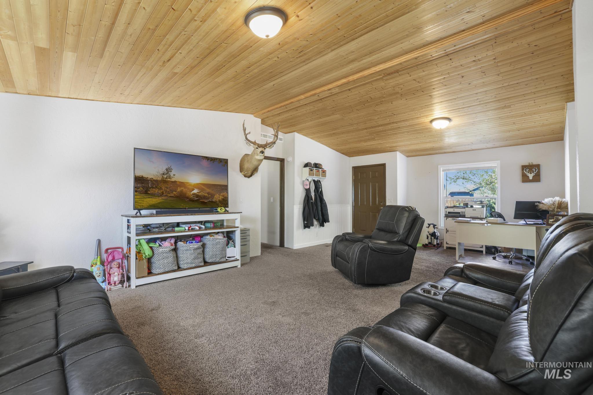309 North Grape Street Shoshone, ID 83352 - Photo 3 of 26 Carpeted living area featuring a vaulted wood ceiling and baseboards
