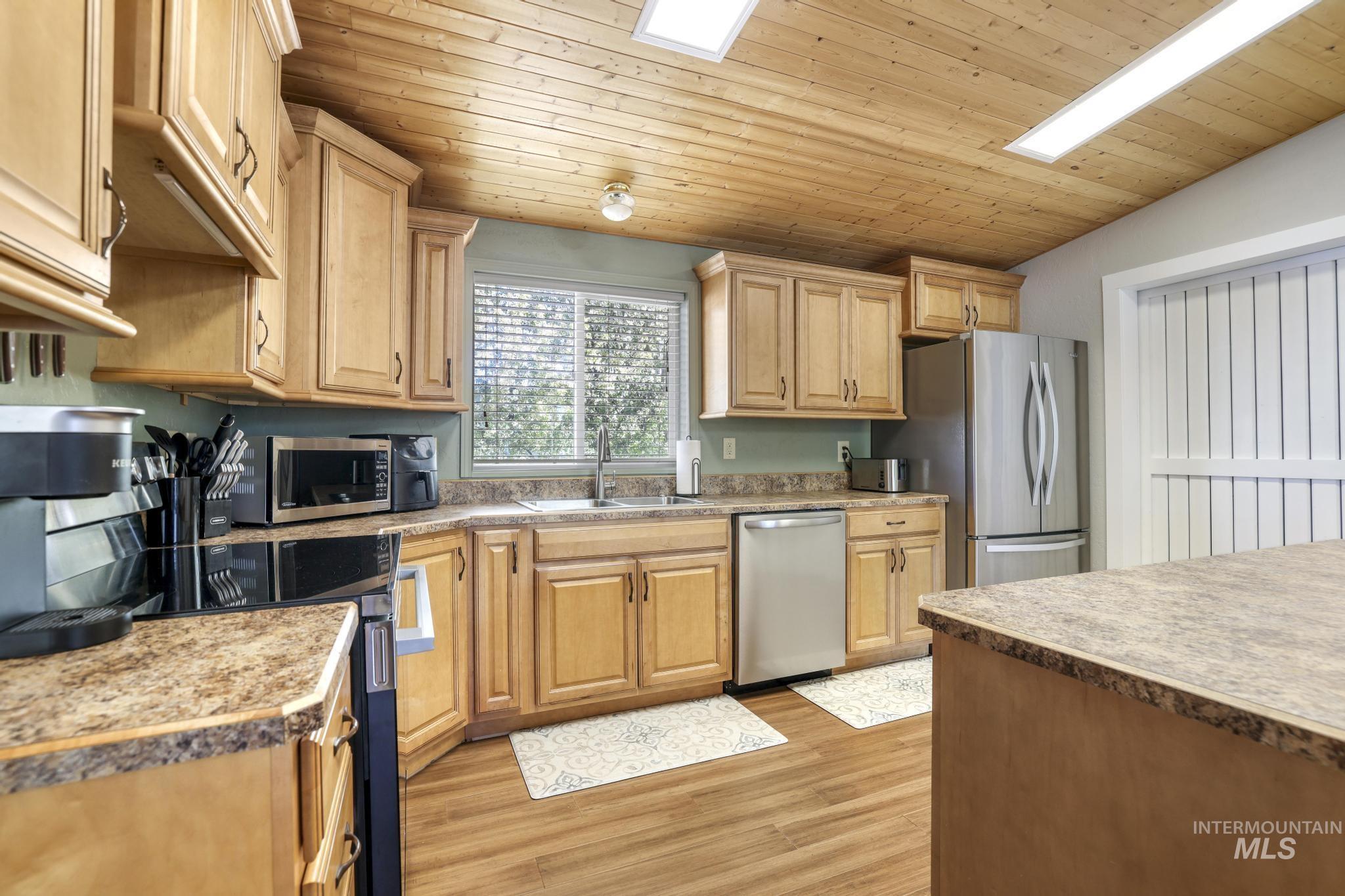 309 North Grape Street Shoshone, ID 83352 - Photo 6 of 26 Kitchen with a vaulted wooden ceiling, stainless steel appliances, light wood-style floors, light countertops, and light wood finish cabinetry