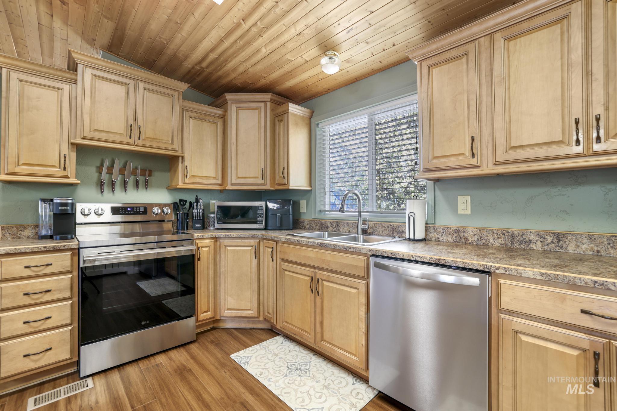 309 North Grape Street Shoshone, ID 83352 - Photo 8 of 26 Kitchen featuring stainless steel appliances, light wood finish cabinets, wood ceiling, and light wood-style floors