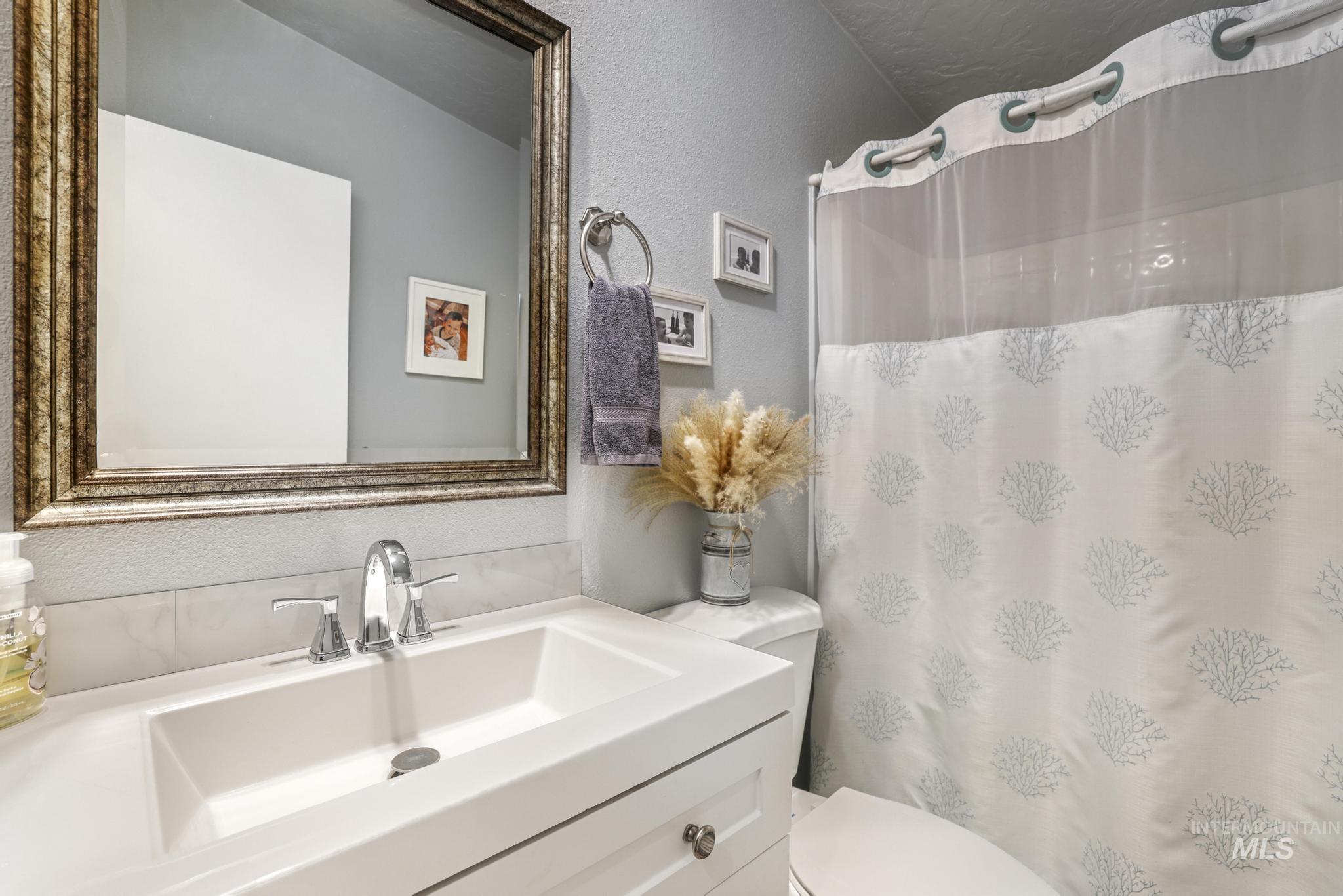 309 North Grape Street Shoshone, ID 83352 - Photo 10 of 26 Full bath with a textured wall, vanity, and a shower with shower curtain