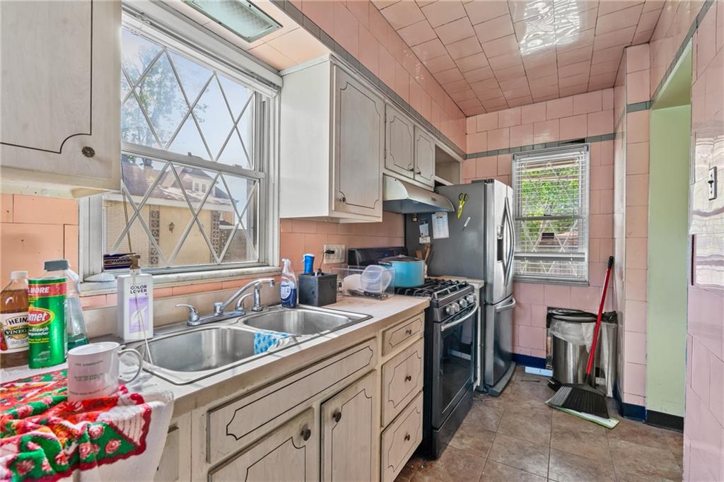 1503 Beechview Avenue Pittsburgh, PA 15216 - Photo 11 of 26 a kitchen with stainless steel appliances granite countertop a sink stove and cabinets