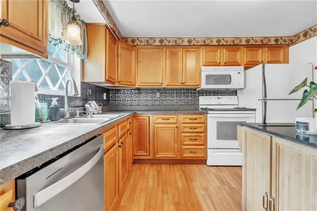 a kitchen with stainless steel appliances a sink cabinets and a wooden floor